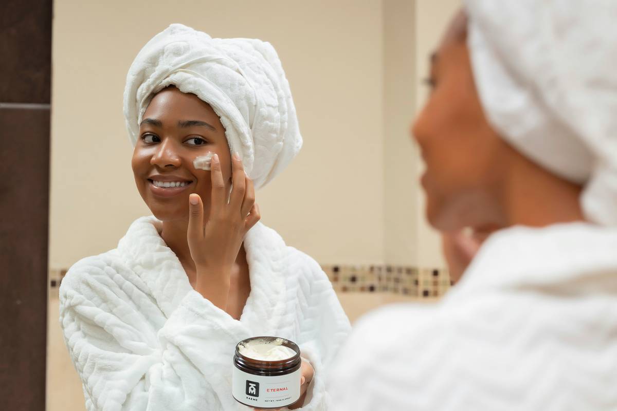 Cleansing body wipes for adults laid flat on a white marble counter, showing textured surface, visible cotton-fiber weave, and subtle sheen of botanical extract