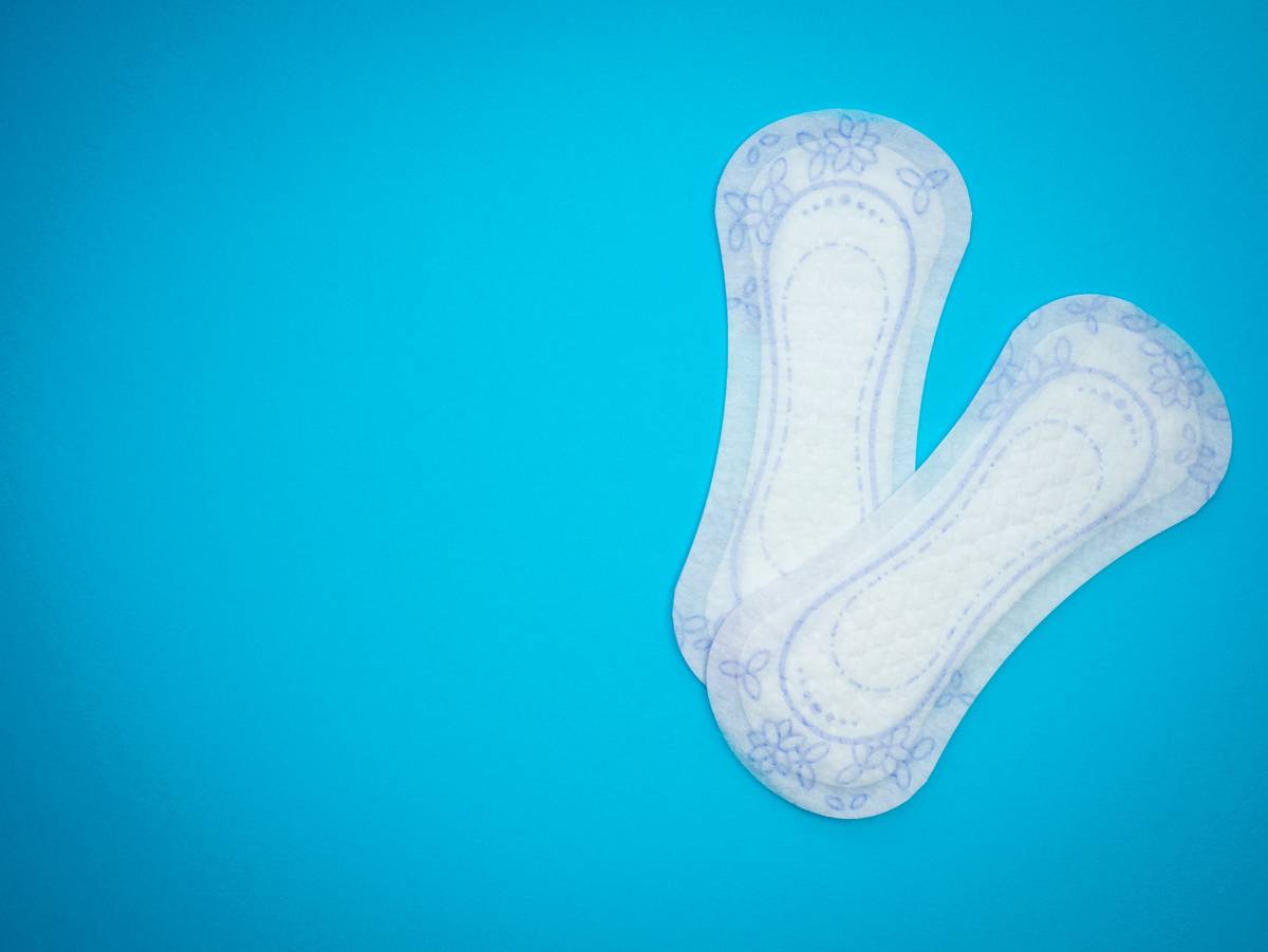 Close-up of gentle hygiene wipes for women in eco-friendly packaging next to fresh cotton pads